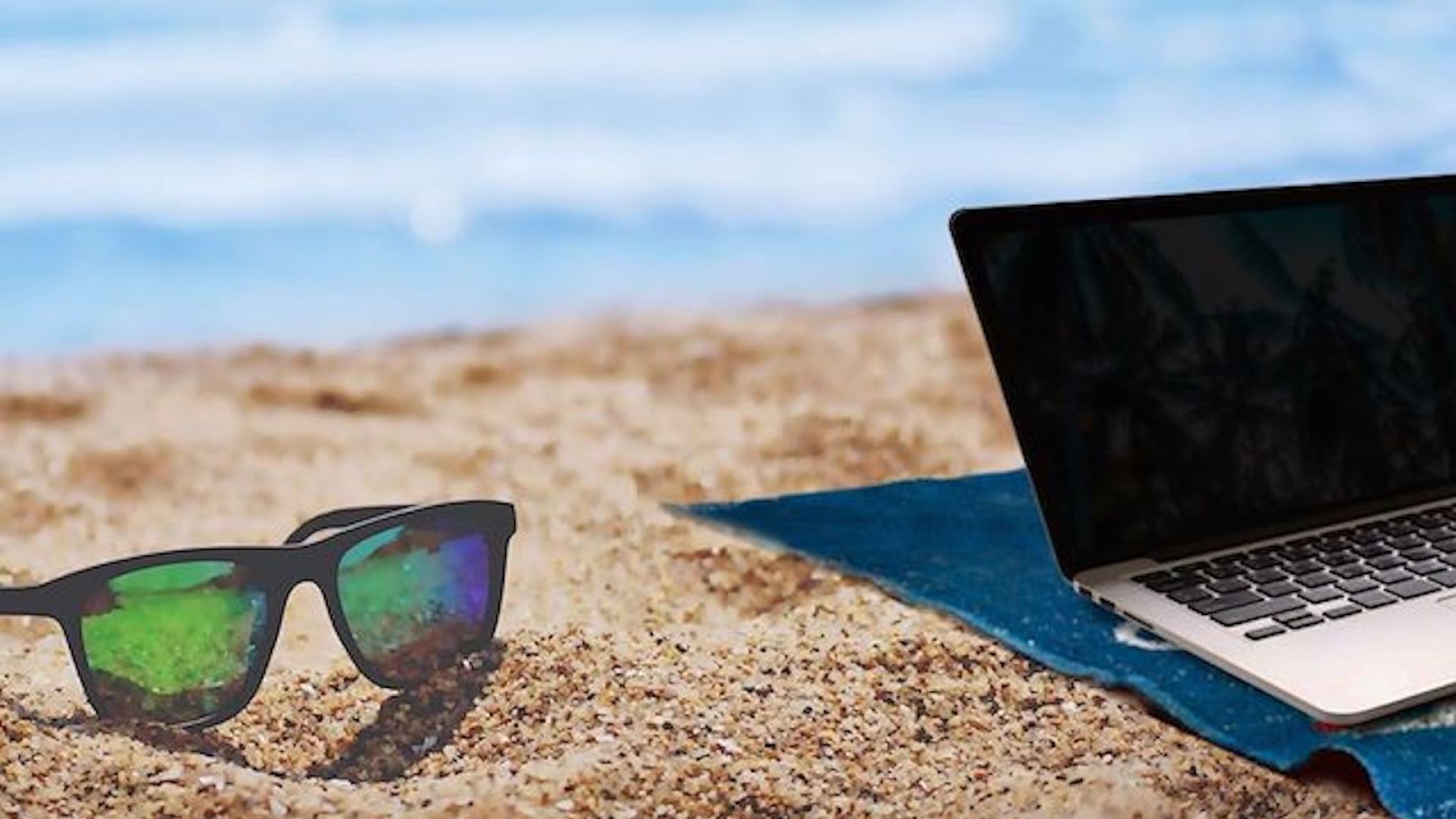 A Close Up Of A Laptop Computer Sitting On Top Of A Beach